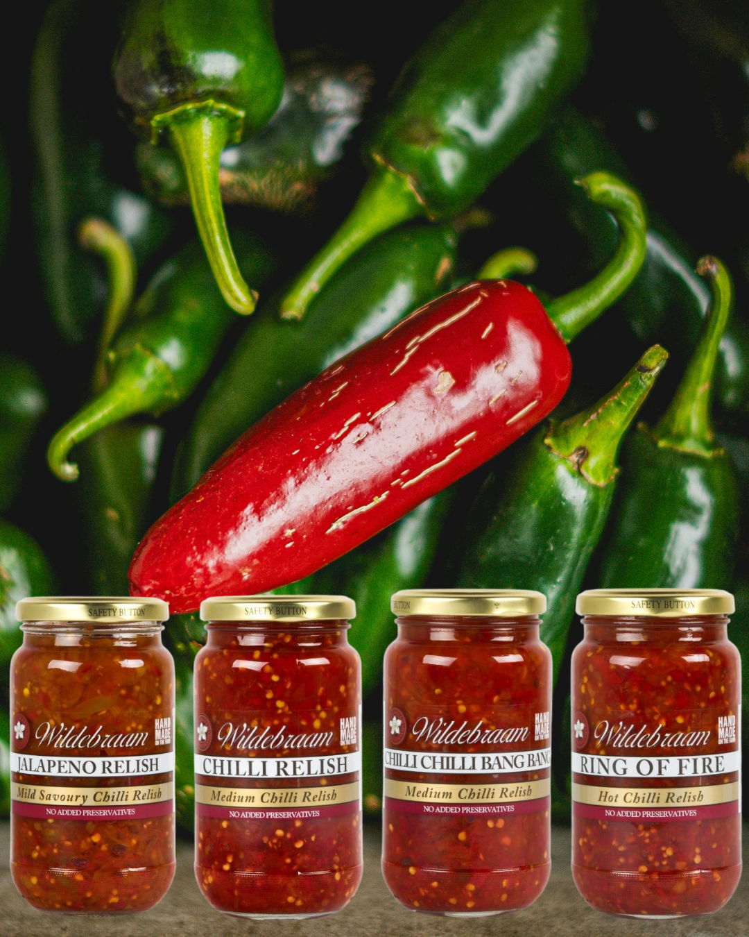 Jars of Wildebraam chili relish with green and red chili peppers in the background